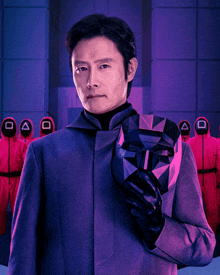 a man in a purple suit is holding a mask in front of a group of soldiers in red uniforms