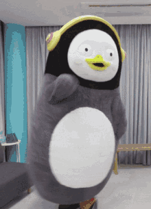 a stuffed penguin is wearing headphones and dancing