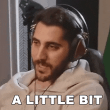 a man wearing headphones says " a little bit " on the screen