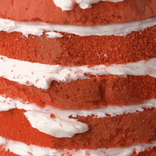 a red velvet cake with white frosting is stacked on top of itself