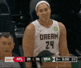 a female basketball player wearing a white jersey that says dream 24