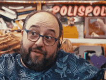 a man wearing glasses and headphones is standing in front of a sign that says polispol
