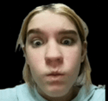 a close up of a woman making a funny face with her eyes wide open .
