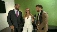 a man in a suit holds a microphone that says abw