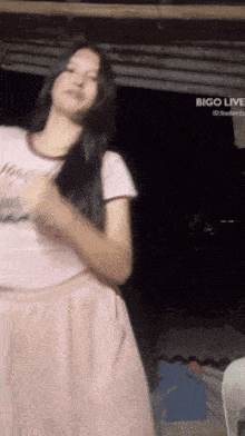 a woman dancing in front of a bigo live sign