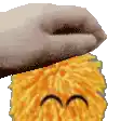 a close up of a person 's hand holding a stuffed animal .