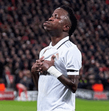 a soccer player wearing a white shirt that says fly emirates on the front