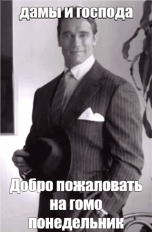 a man in a suit and tie is holding a hat and says " добро пожаловать на gomo "