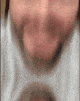 a blurry picture of a person 's face with a white shirt