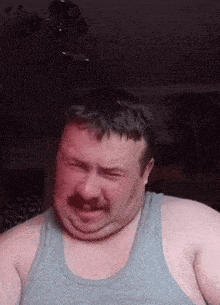 a man with a mustache is making a funny face .