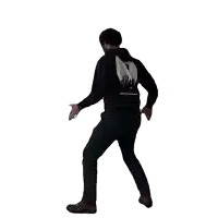 a man wearing a black sweatshirt with a skull on the back is dancing