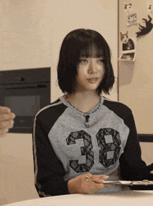 a woman wearing a sweater with the number 38 on it