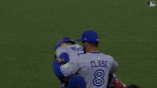 a baseball player wearing a blue jays jersey is being congratulated by his teammates