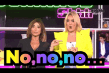 two women standing in front of a sign that says no.no.no.