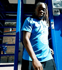 a man wearing a blue shirt with a circle on it