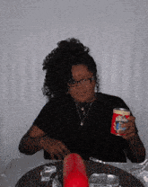 a woman sitting at a table with a can of condensed milk in her hand