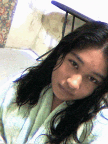 a girl with long hair is wearing a green towel