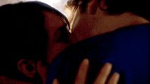 a woman kisses a man on the cheek in a blurry photo