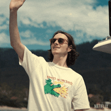 a man wearing a hater incinerator t-shirt is waving his hand