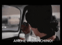 a woman is sitting in a car with the words anche imbianchino written on the screen