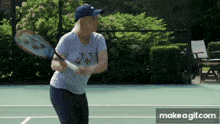 a woman is holding a tennis racquet on a tennis court ..