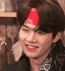 a close up of a person wearing a red bandana on their head .