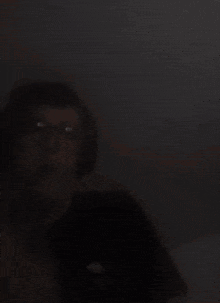 a person wearing glasses and headphones in the dark .