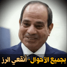 a man in a suit and tie is smiling in front of a sign in arabic
