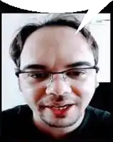 a man with glasses and a beard is smiling and talking .