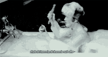 a man is taking a bath in a bathtub with foam on his head and shaving his face .