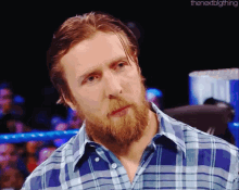 a man with a beard wearing a plaid shirt with the nextbigthing written below him