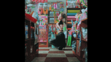a woman in a black top is kneeling in a store filled with toys