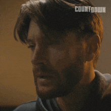 a close up of a man 's face with the word countdown written on his hair