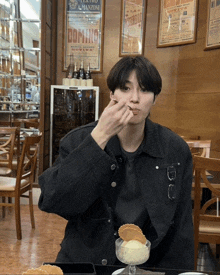 a man eating ice cream in a restaurant with domino posters hanging on the wall behind him