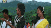 a man and a woman are dancing in front of a mountain and the words mango music are on the bottom