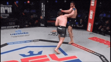 two men are fighting in a ring with a banner that says upside