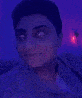 a woman is making a funny face in front of a blue light .