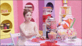 a woman in a white dress is sitting at a table with a bubble gum machine in the background