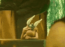 a cartoon character wearing a helmet with white wings