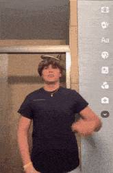 a man in a blue shirt is standing in front of a wall with icons for aa and a