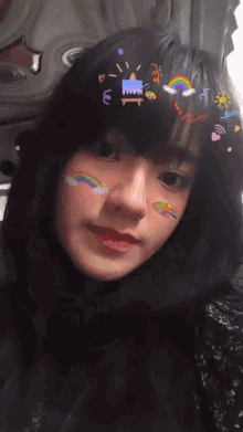 a young girl with stickers on her face including a rainbow