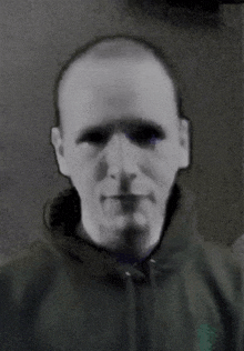 a black and white photo of a man wearing a green polo shirt