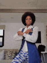 a woman in a white shirt and blue vest is dancing