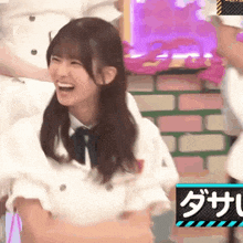 a girl in a white shirt and tie is laughing while holding a white rabbit .