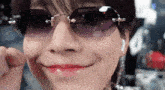 a close up of a woman wearing sunglasses making a funny face .