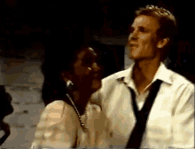 a man in a white shirt and tie is talking to a woman