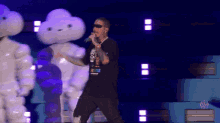 a man singing into a microphone while wearing sunglasses and a shirt that says ' a few things ' on it