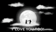 a couple is standing in front of a full moon in a black and white photo .