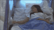 a woman is laying in a hospital bed with an oxygen mask on her face