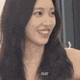 a close up of a woman 's face with long hair and a smile on her face .